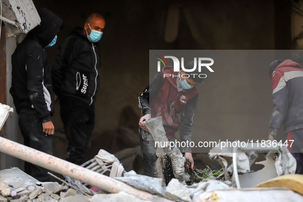 People stand on the rubble of a building after an Israeli strike in Nuseirat, Gaza Strip, on December 5, 2024, as the war between Israel and...