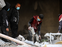 People stand on the rubble of a building after an Israeli strike in Nuseirat, Gaza Strip, on December 5, 2024, as the war between Israel and...