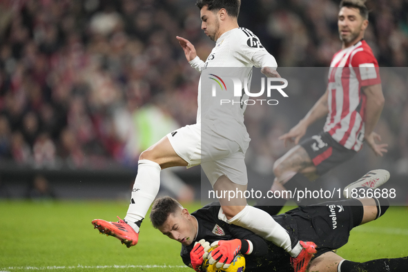 Brahim Diaz attacking midfield of Real Madrid and Spain and Julen Agirrezabala goalkeeper of Athletic Club and Spain compete for the ball du...