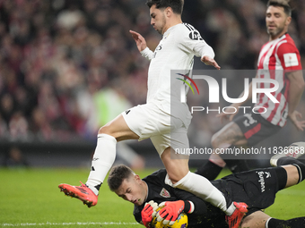 Brahim Diaz attacking midfield of Real Madrid and Spain and Julen Agirrezabala goalkeeper of Athletic Club and Spain compete for the ball du...