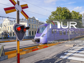 An SJ Swedish railway company train crosses the level crossing in Ystad, Sweden, on August 4, 2024. (