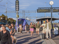 People get off the train on the platform of the train station in Ystad, Sweden, on August 4, 2024. (