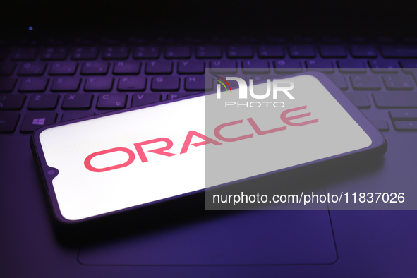 The Oracle Corporation logo appears on the screen of a smartphone in Reno, United States, on December 5, 2024. 