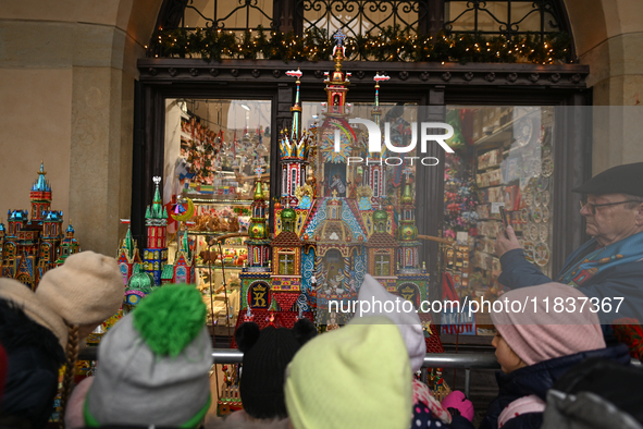 KRAKOW, POLAND - DECEMBER 05:
Visitors, tourists, and locals gather in Krakow's Main Square, capturing photos of the detailed handcrafted Na...