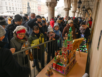 KRAKOW, POLAND - DECEMBER 05:
Visitors, tourists, and locals gather in Krakow's Main Square, capturing photos of the detailed handcrafted Na...