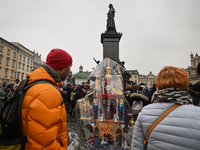 KRAKOW, POLAND - DECEMBER 05:
Visitors, tourists, and locals gather in Krakow's Main Square, capturing photos of the detailed handcrafted Na...