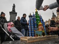 KRAKOW, POLAND - DECEMBER 05:
Visitors, tourists, and locals gather in Krakow's Main Square, capturing photos of the detailed handcrafted Na...