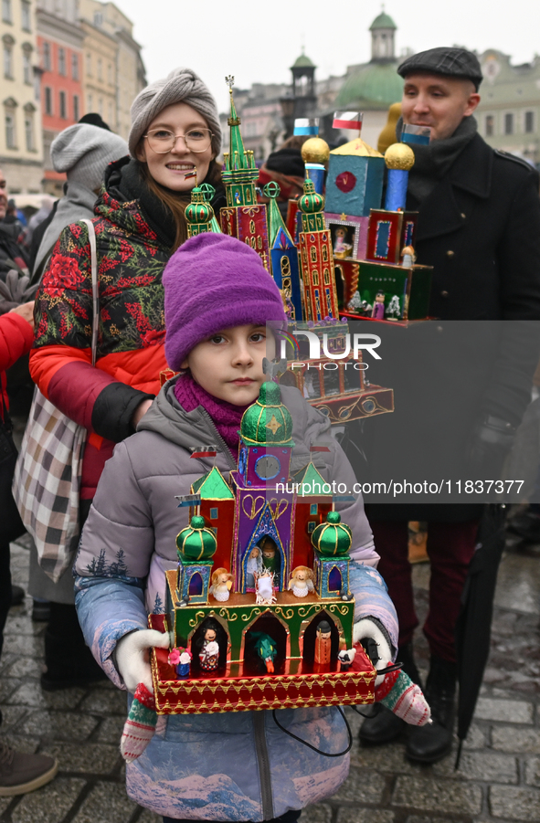 KRAKOW, POLAND - DECEMBER 05:
A family of contestants showcases their handcrafted Nativity Scene in Krakow's Main Square during the 82nd Nat...