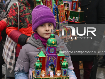 KRAKOW, POLAND - DECEMBER 05:
A family of contestants showcases their handcrafted Nativity Scene in Krakow's Main Square during the 82nd Nat...