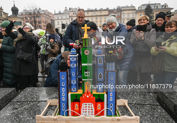 KRAKOW, POLAND - DECEMBER 05:
Visitors, tourists, and locals gather in Krakow's Main Square, capturing photos of the detailed handcrafted Na...