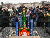 KRAKOW, POLAND - DECEMBER 05:
Visitors, tourists, and locals gather in Krakow's Main Square, capturing photos of the detailed handcrafted Na...