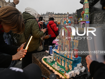 KRAKOW, POLAND - DECEMBER 05:
Visitors, tourists, and locals gather in Krakow's Main Square, capturing photos of the detailed handcrafted Na...