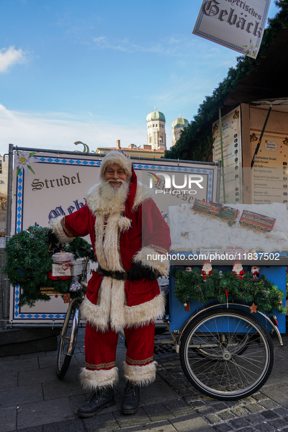 Santa Claus rides a festively decorated bicycle at the Christmas market in Munich, Germany, on December 5, 2024. 