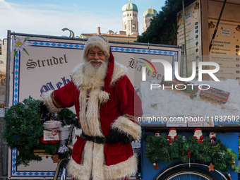 Santa Claus rides a festively decorated bicycle at the Christmas market in Munich, Germany, on December 5, 2024. (