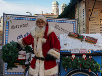 Santa Claus rides a festively decorated bicycle at the Christmas market in Munich, Germany, on December 5, 2024. (