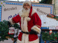 Santa Claus rides a festively decorated bicycle at the Christmas market in Munich, Germany, on December 5, 2024. (