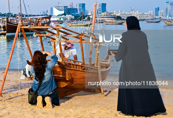 Visitors take pictures during the 14th Katara Traditional Dhow Festival in Katara Cultural Village in Doha, Qatar, on December 5, 2024. The...