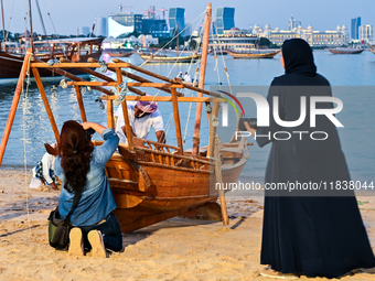 Visitors take pictures during the 14th Katara Traditional Dhow Festival in Katara Cultural Village in Doha, Qatar, on December 5, 2024. The...