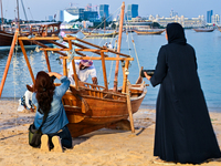 Visitors take pictures during the 14th Katara Traditional Dhow Festival in Katara Cultural Village in Doha, Qatar, on December 5, 2024. The...