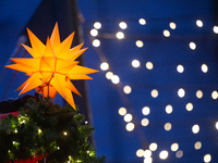 A general view of a Christmas star light is installed against the Dom Cathedral at the Cologne Christmas Market in Cologne, Germany, on Dece...