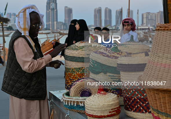 An Arab fisherman stacks baskets and mats made of palm leaves during the 14th Katara Traditional Dhow Festival in Katara Cultural Village in...