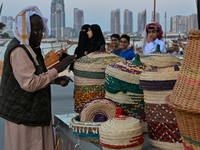 An Arab fisherman stacks baskets and mats made of palm leaves during the 14th Katara Traditional Dhow Festival in Katara Cultural Village in...