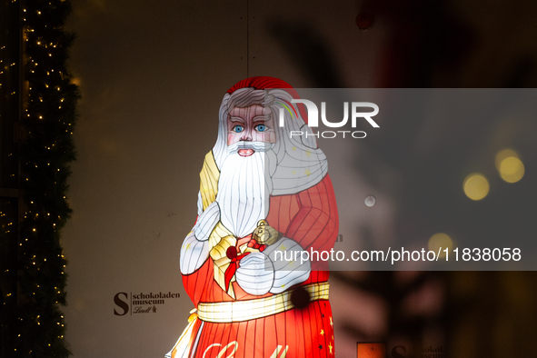 A general view shows an illuminated Lindt Santa Claus figure in front of the Lindt Chocolate Museum at the Cologne Harbor Christmas Market i...