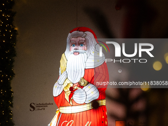 A general view shows an illuminated Lindt Santa Claus figure in front of the Lindt Chocolate Museum at the Cologne Harbor Christmas Market i...