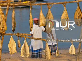 A fisherman demonstrates a traditional fish drying process during the 14th Katara Traditional Dhow Festival in Katara Cultural Village in Do...