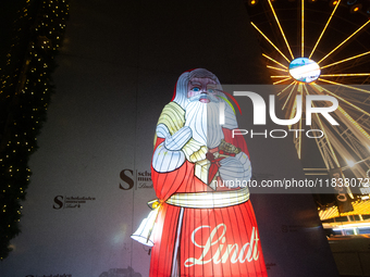 A general view shows an illuminated Lindt Santa Claus figure in front of the Lindt Chocolate Museum at the Cologne Harbor Christmas Market i...