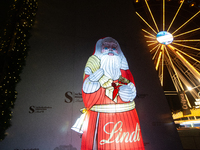 A general view shows an illuminated Lindt Santa Claus figure in front of the Lindt Chocolate Museum at the Cologne Harbor Christmas Market i...