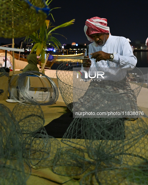 A man makes handicrafts during the 14th Katara Traditional Dhow Festival in Katara Cultural Village in Doha, Qatar, on December 5, 2024. The...