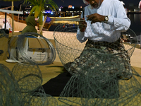 A man makes handicrafts during the 14th Katara Traditional Dhow Festival in Katara Cultural Village in Doha, Qatar, on December 5, 2024. The...