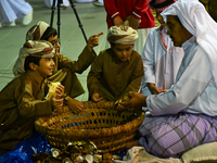 A Qatari man opens an oyster and extracts pearls during the 14th Katara Traditional Dhow Festival in Katara Cultural Village in Doha, Qatar,...