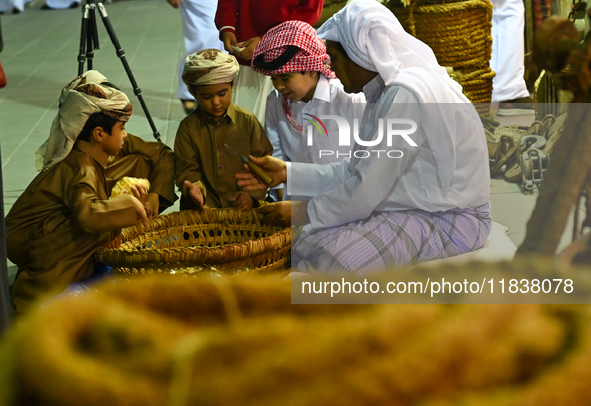 A Qatari man opens an oyster and extracts pearls during the 14th Katara Traditional Dhow Festival in Katara Cultural Village in Doha, Qatar,...