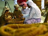 A Qatari man opens an oyster and extracts pearls during the 14th Katara Traditional Dhow Festival in Katara Cultural Village in Doha, Qatar,...