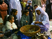 A Qatari man opens an oyster and extracts pearls during the 14th Katara Traditional Dhow Festival in Katara Cultural Village in Doha, Qatar,...