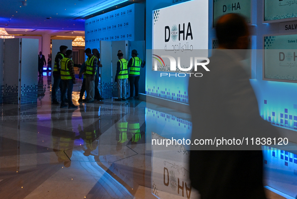 Workers make final preparations at the Doha Forum venue inside the Sheraton Grand Doha Resort & Convention Hotel ahead of the 22nd edition o...