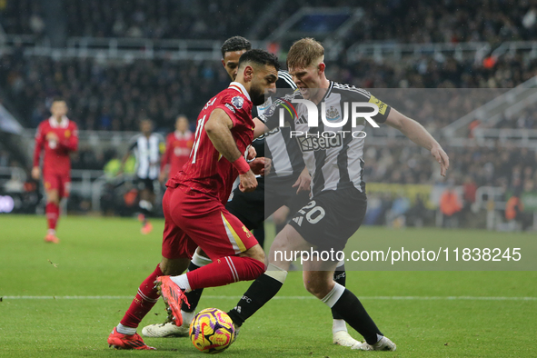 Newcastle United's Lewis Hall tackles Liverpool's Mohamed Salah during the Premier League match between Newcastle United and Liverpool at St...