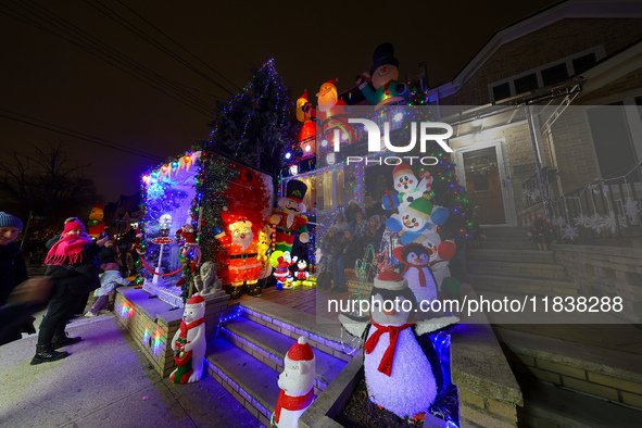 People gather to see and photograph the holiday lights at a home in the Dyker Heights section of Brooklyn, N.Y., on December 4, 2024. Dyker...