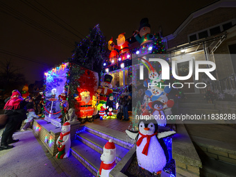 People gather to see and photograph the holiday lights at a home in the Dyker Heights section of Brooklyn, N.Y., on December 4, 2024. Dyker...