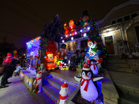 People gather to see and photograph the holiday lights at a home in the Dyker Heights section of Brooklyn, N.Y., on December 4, 2024. Dyker...