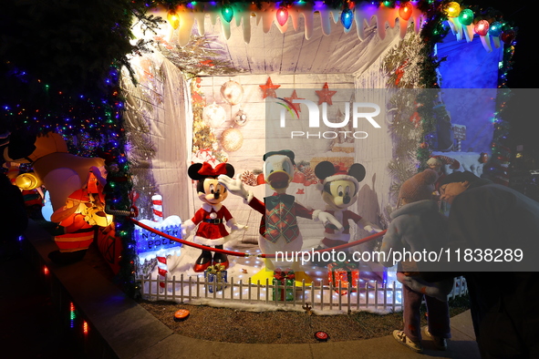 People gather to see and photograph the holiday lights at a home in the Dyker Heights section of Brooklyn, N.Y., on December 4, 2024. Dyker...