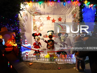 People gather to see and photograph the holiday lights at a home in the Dyker Heights section of Brooklyn, N.Y., on December 4, 2024. Dyker...