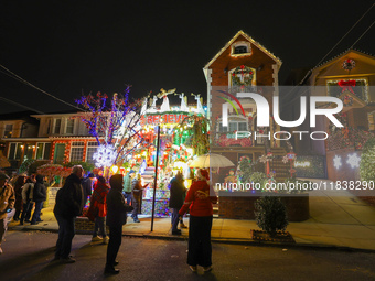 People gather to see and photograph the holiday lights at a home in the Dyker Heights section of Brooklyn, N.Y., on December 4, 2024. Dyker...