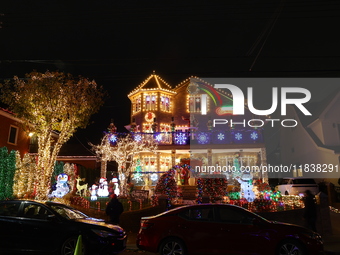 People gather to see and photograph the holiday lights at a home in the Dyker Heights section of Brooklyn, N.Y., on December 4, 2024. Dyker...