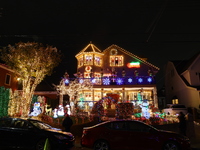 People gather to see and photograph the holiday lights at a home in the Dyker Heights section of Brooklyn, N.Y., on December 4, 2024. Dyker...