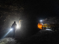 Workers load mined phosphate rocks into trucks at the plant of the Ferriichong phosphate mine in Hualuo village, Sanjia street, Zhijin Count...