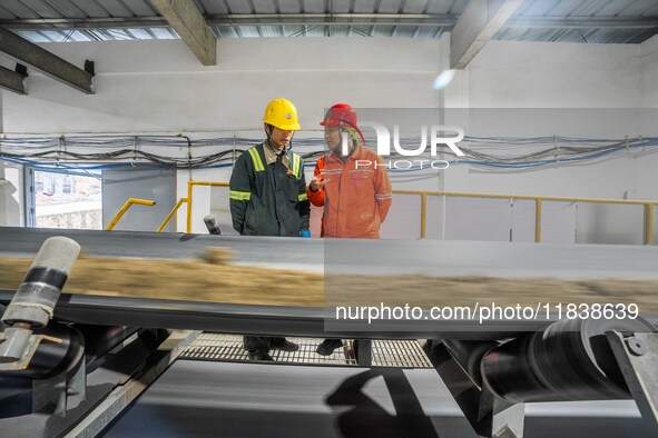 Workers carry out a routine inspection on a conveyor belt at the Ferris Chong phosphate mine in Hualuo village, Sanjia street, Zhijin County...