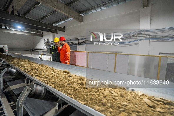 Workers carry out a routine inspection on a conveyor belt at the Ferris Chong phosphate mine in Hualuo village, Sanjia street, Zhijin County...